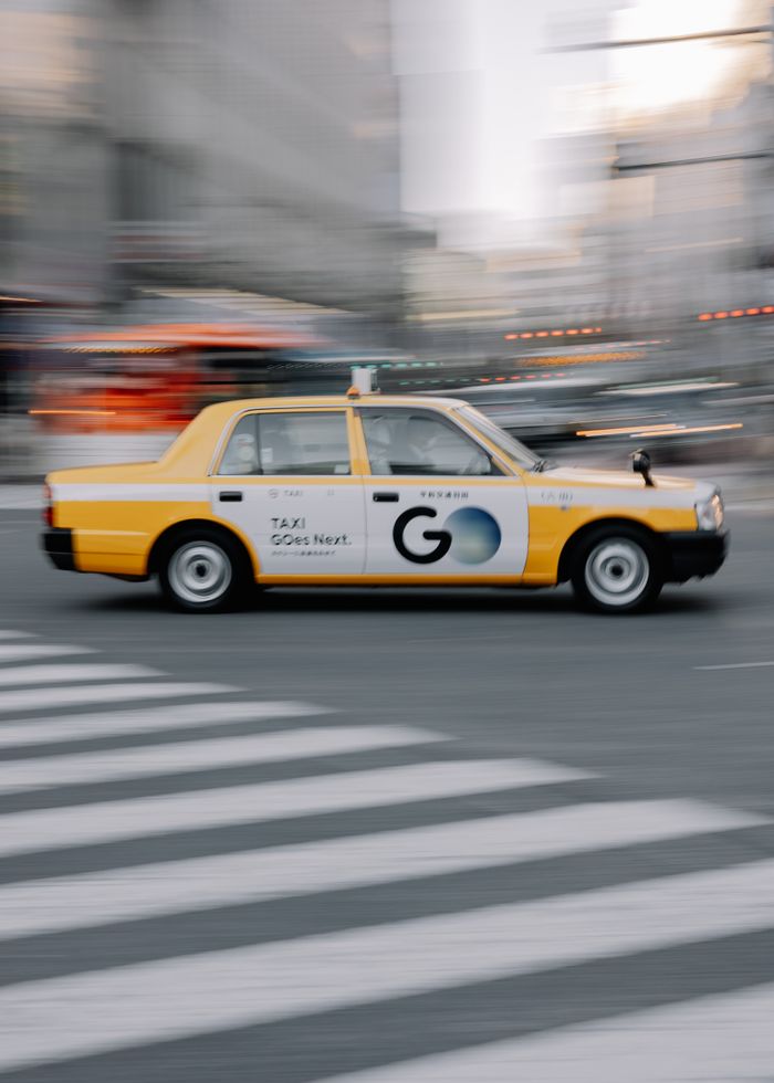 gallery-4 A dynamic view of a taxi speeding across a crosswalk in downtown Shibuya, Tokyo.