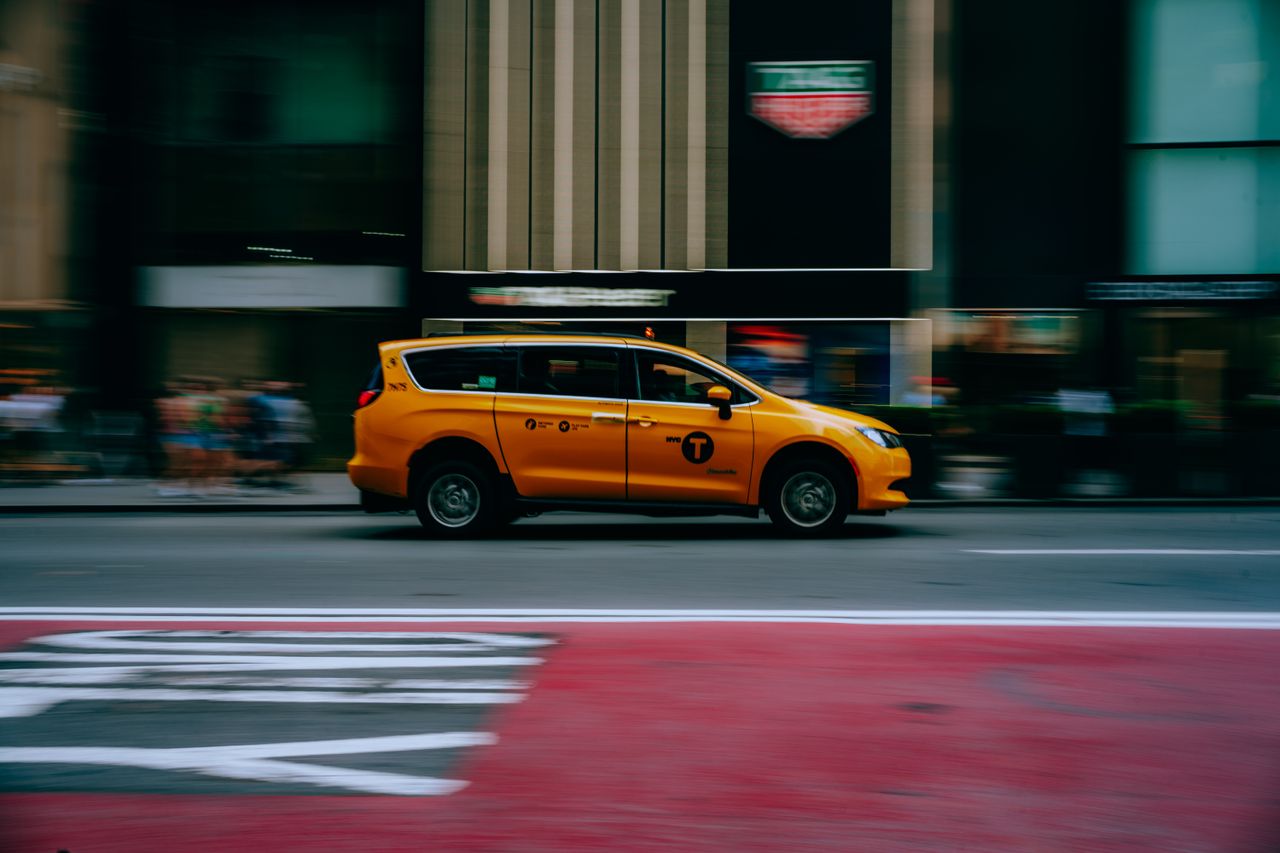 gallery-2 Dynamic shot of a yellow taxi speeding through a New York City street.