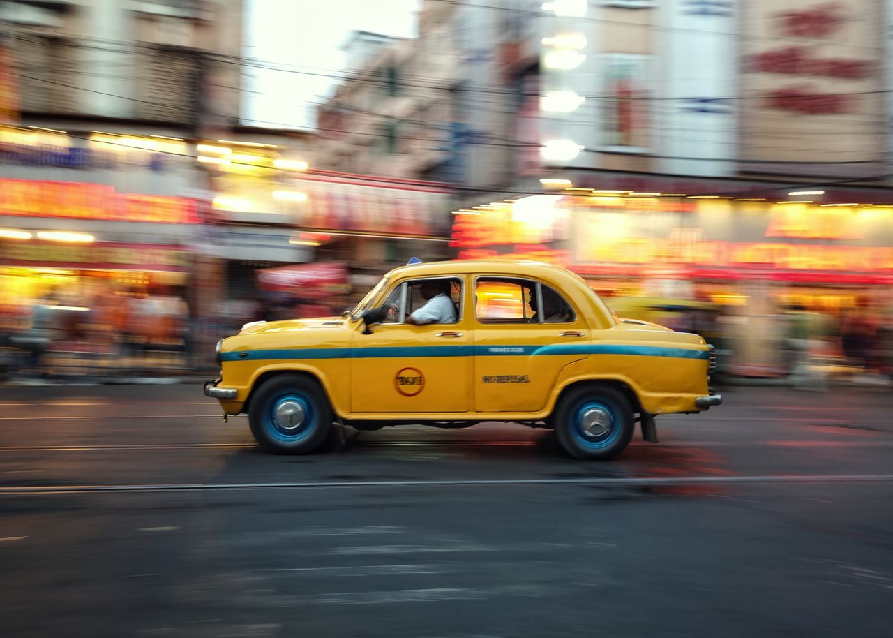 why-choose-us A yellow taxi speeds through bustling city streets, capturing the essence of urban life.