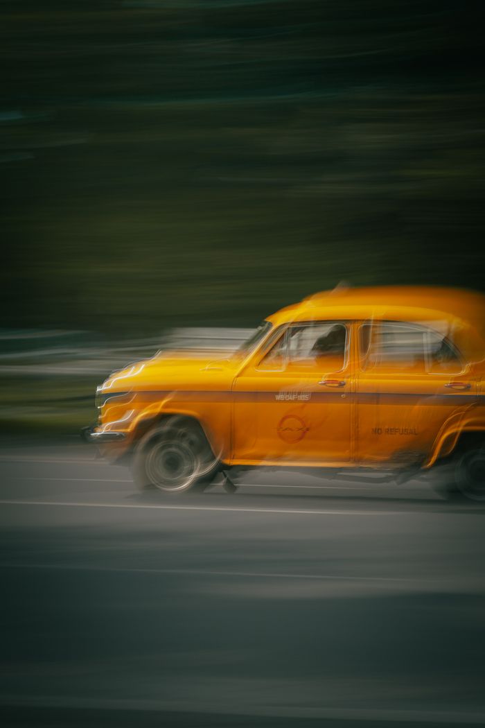 gallery-3 A classic yellow taxi captured in motion blur, representing fast-paced urban life in India.